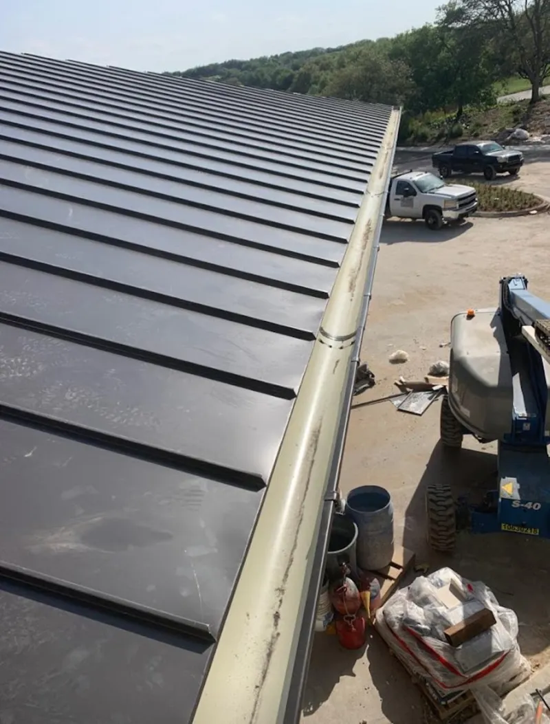 Standing seam panel and gutter detail on a metal roofing jobsite in Waltham